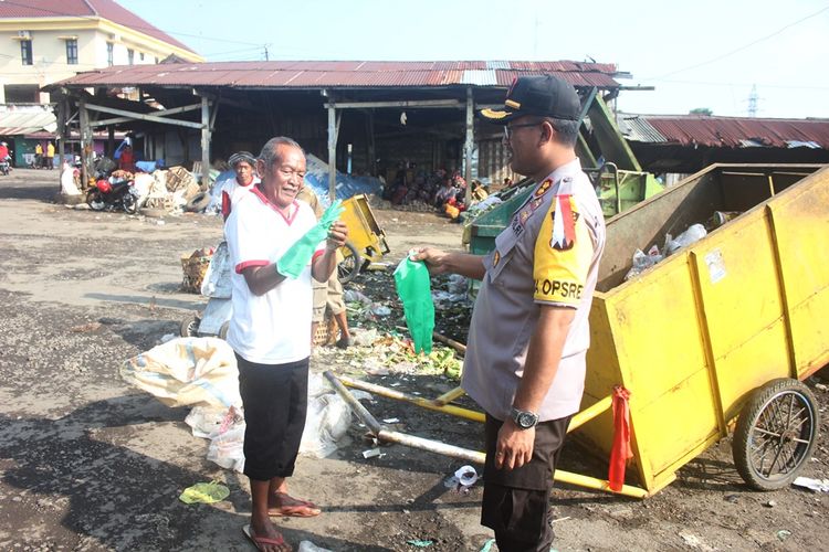 Kapolres Magetan AKBP Muhammad Riffai memberikan sarung tangan kepada salah satu pekerja sampah, Rabu (20/2/2019). 