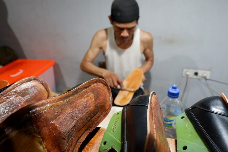 Seorang perajin tengah mengerjakan sepatu Minen, merk sepatu di Bandung yang sudah tembus pasar dunia.