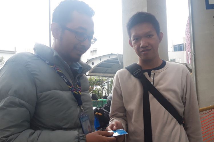 Salah satu penumpang JAK 24 saat menerima kartu naik LRT Jakarta dari petugas, Rabu (6/3/2019)