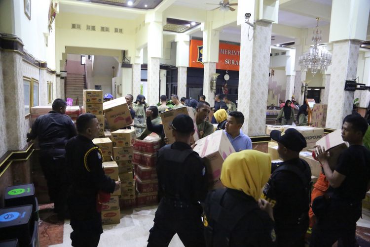 Petugas BPB dan Linmas melakukan packing barang yang akan dikirim untuk bantuan korban bencana banjir di Kabupaten Madiun dan Ponorogo, Kamis (7/3/2019).