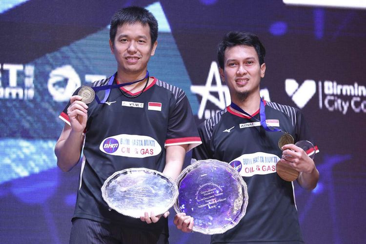 Pebulu tangkis ganda putra Indonesia Hendra Setiawan (kiri) dan Mohammad Ahsan menunjukan medali usai memenangi pertandingan melawan ganda putra Malaysia Aaron Chia dan Soh Wooi Yik pada babak final All England 2019 di Arena Brimingham, Inggris, Minggu (8/3/2019).