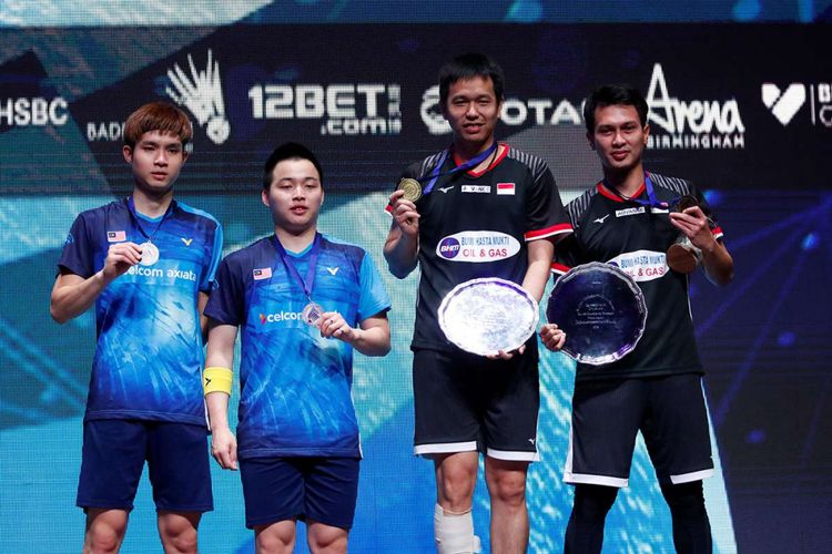 Pebulu tangkis ganda putra Indonesia, Hendra Setiawan (kedua kanan) dan Mohammad Ahsan (kanan), menunjukkan medali mereka usai menang atas pasangan Malaysia Aaron Chia dan Wooi Yik Soh dalam final ganda putra All England di Birmingham, Inggris, Minggu (10/3/2019). 