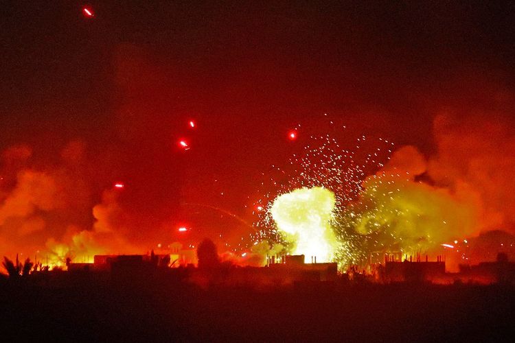 Dalam foto yang diambil pada 11 Maret 2019, desa Baghouz menyala di malam hari oleh serangan Pasukan Demokratik Suriah (SDF). Baghouz merupakan benteng terakhir ISIS, dan saat ini digempur koalisi pimpinan AS.