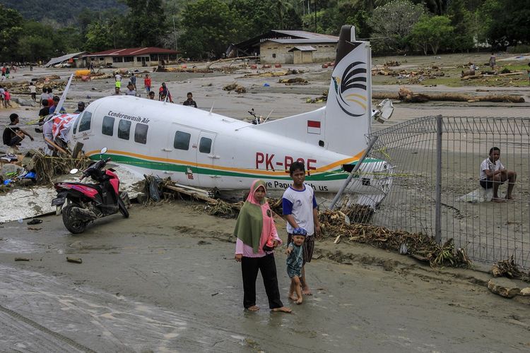 Warga berada di dekat pesawat udara yang terdampak banjir bandang di Sentani, Kabupaten Jayapura, Papua, Minggu (17/3/2019). Berdasarkan data BNPB, banjir bandang yang terjadi pada Sabtu (16/3/2019) tersebut mengakibatkan 63 orang meninggal dunia. ANTARA FOTO/Gusti Tanati/sgd/wsj.