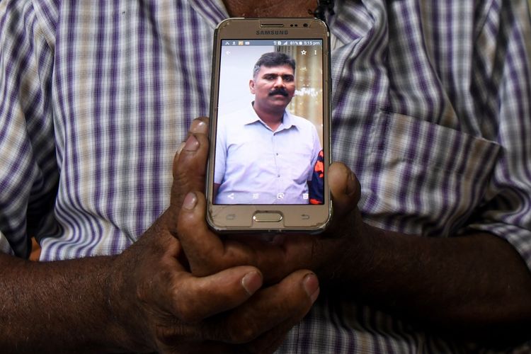 Foto yang diambil pada 26 April 2019 memperlihatkan Velusami Raju ketika memegang foto sang anak, Ramesh Raju, yang menjadi pahlawan karena tewas ketika menghentikan pelaku bom bunuh diri di Gereja Zion, Batticaloa, Sri Lanka, pada Minggu pekan lalu (21/4/2019).