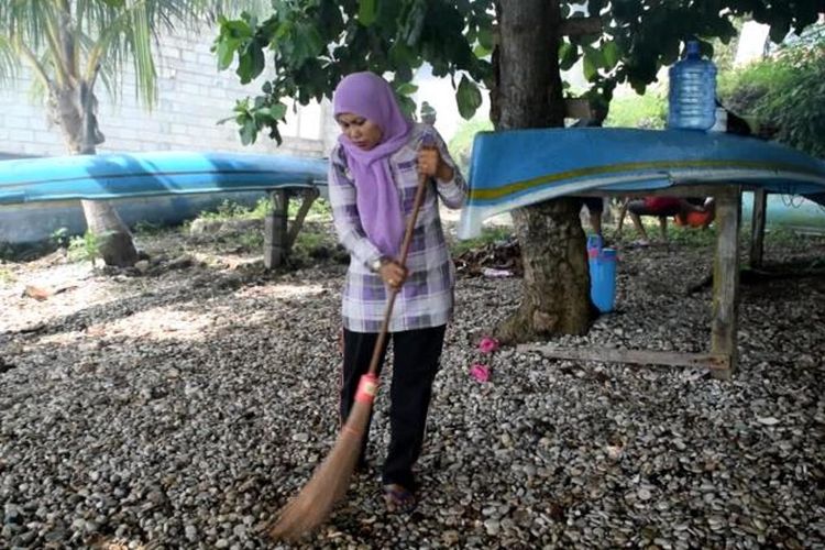 Seorang ibu warga Lingkungan Lingges-lingge, Kelurahan Pasarwajo, Kecamatan Pasarwajo, membersihkan sampah di pantai.  