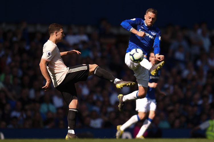 Pemain Manchester United, Diogo Dalot (kiri), berduel dengan gelandang Everton, Gylfi Sigurdsson (kanan), pada lanjutan laga Liga Inggris di Goodison Park, Liverpool, Minggu (21/4/2019).