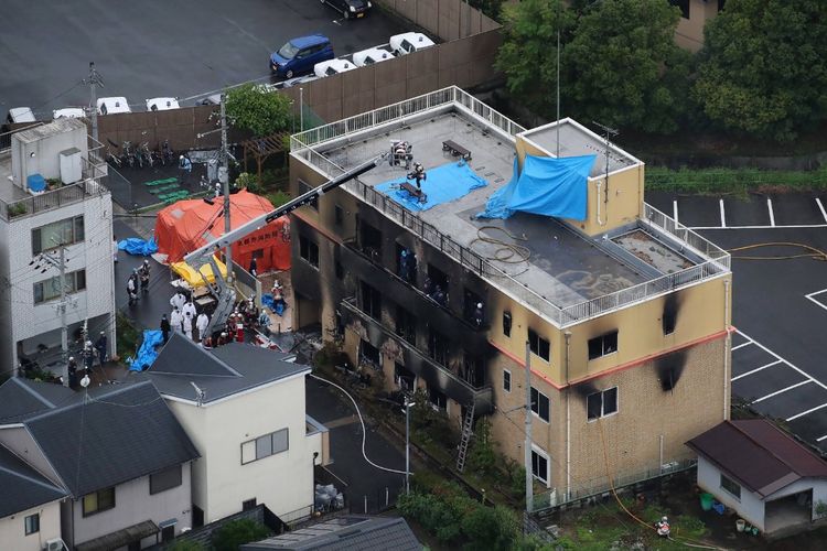 Pemandangan dari atas menunjukkan petugas pemadam kebakaran dan tim penolong berada di gedung studio Kyoto Animation Co yang terbakar di Kyoto, Jepang, Kamis (18/7/2019). Lebih dari 20 orang tewas dalam kebakaran yang disengaja itu.