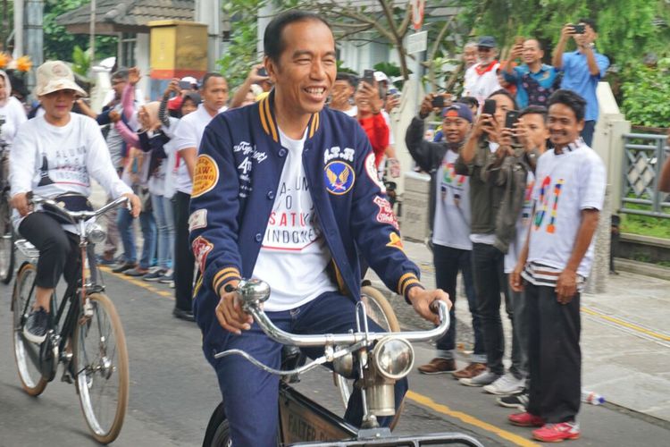 Capres no urut 1 Joko Widodo saat menaiki sepeda onthel melintas di Jalan Suroto menuju lokasi acara deklarasi “Alumni Jogja SATUkan Indonesia” di Stadion Kridosono,  
