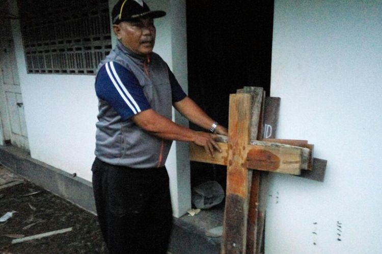 pengurus Makam RS Bethesda, Hari Yuniarto saat menunjukan nisan kayu yang tercabut dari tempatnya