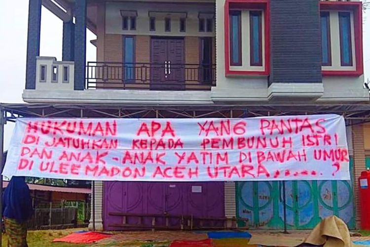 Keluarga dari korban pembunuhan sadis satu istri dan dua anak membentangkan spanduk di rumah duka di Desa Ulee Madon, Kecamatan Muara Batu, Kabupaten Aceh Utara, Sabtu (11/5/2019)