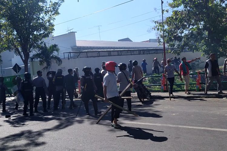 Polisi mengejar massa yang melakukan kerusuhan dalam aksi yang digelar di samping kantor Polres Pamekasan, Rabu (22/5/2019).
