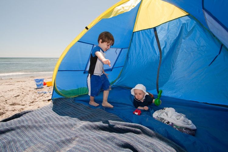 Membawa tenda saat ke pantai bisa dilakukan saat ke pantai bareng si kecil