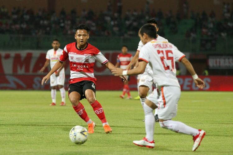 Winger Persija Jakarta, Riko Simanjuntak (putih), berhadapan dengan gelandang Madura United, Syahrian Abimanyu (merah). Laga Madura United vs Persija Jakarta yang dihelat di Stadion Gelora Madura Ratu Pamelingan, Jumat (16/8/2019), berakhir dengan skor imbang 2-2. 