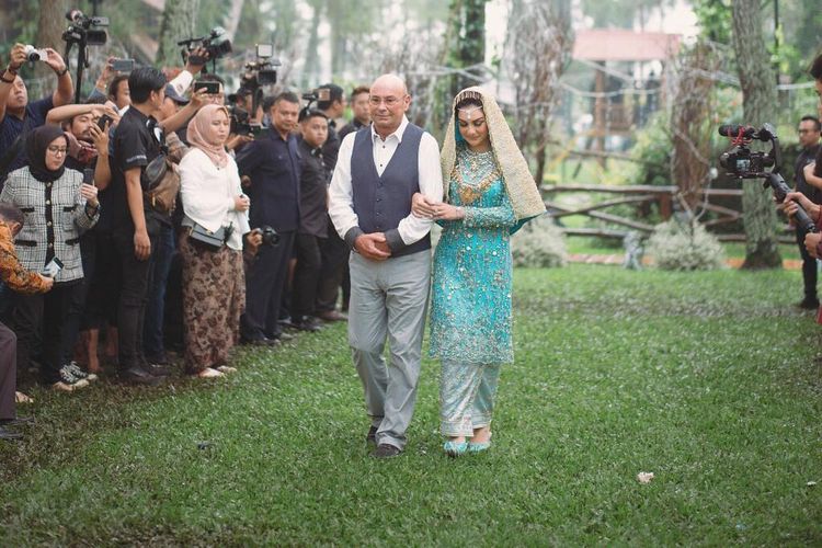 Irish Bella digandeng pihak keluargannya menuju lokasi akad nikahnya dengan Ammar Zoni di Pine Hill Cibodas, Kawasan Lembang, Cibodas, Bandung Barat, Minggu (28/4/2019) hari ini.