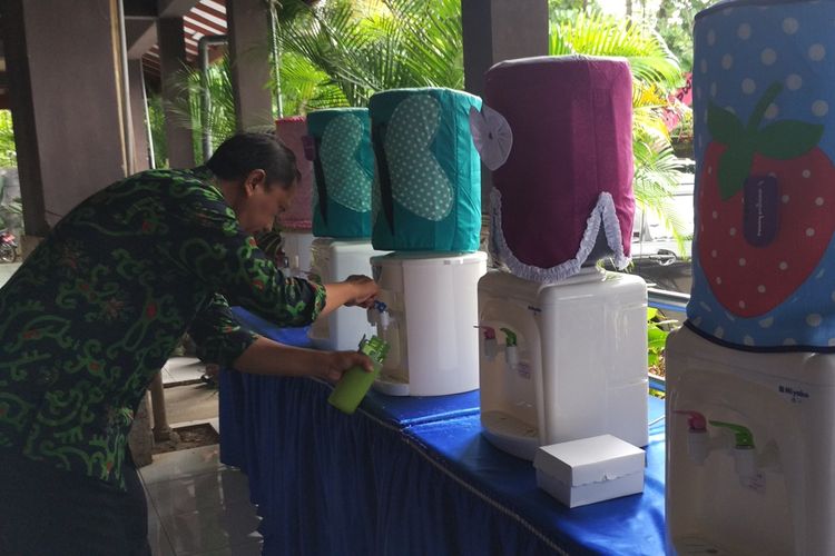 Salah satu aparatur sipil negara (ASN) lingkungan pemerintah kabupaten Trenggalek Jawa Timur, mengisi ulang air ke botol dari Galon yang tersedia di lokasi kegiatan musrenbang (21/03/2019)