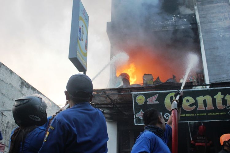 Petugas damkar dari BPBD Kab. Cianjur berupaya memadamkan api yang menghanguskan sebuah bangunan ruko di kawasan Pasar Baru, Muka, Cianjur, Selasa (25/06/2019) pagi