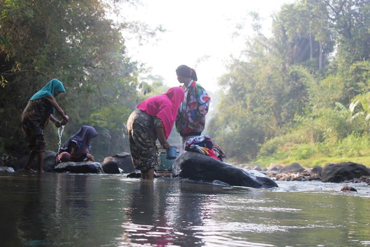 Warga di Kecamatan Cibeber, Cianjur, Jawa Barat sedang mencuci di aliran Leuwi Jambrong, Selasa (02/07/2019). Warga terpaksa menggunakan air sungai untuk kebutuhan MCK karena sumur mereka mengering akibat musim kemarau.