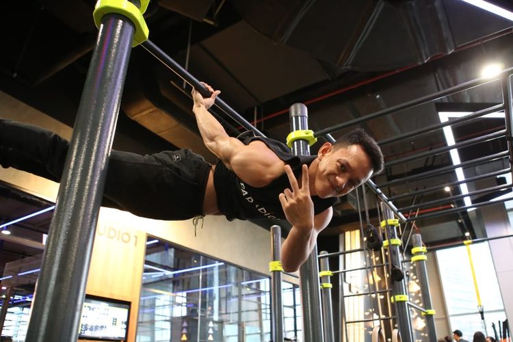 Seorang pelatih di pusat kebugaran Paradigm memeragakan kemahirannya dalam menggunakan alat calisthenics.