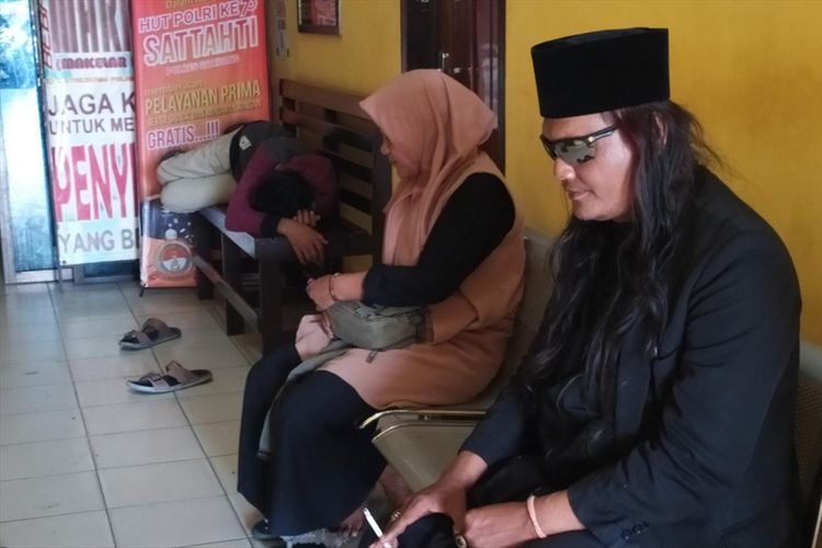 Robi Anjal (38) asal Pontianak, Kalimantan Barat, bersama istri dan anaknya saat menunggu panggilan pemeriksaan polisi di Polres Sampang, Senin (29/7/2019).  Robi adalah pelaku kasus orang mati hidup lagi di Sampang, Madura. 