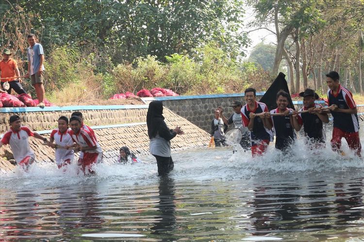 Permainan Bajak Kali di sungai kawasan Ruang Terbuka Hijau (RTH) Kebonratu, Kabupaten Jombang, Jawa Timur, Sabtu (27/7/2019). Permainan tersebut bertujuan untuk menumbuhkan kesadaran dan kepedulian masyarakat terhadap kebersihan sungai.