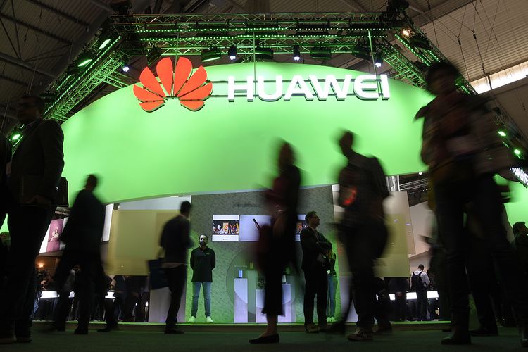 Pengunjung melintas di depan stan perusahaan teknologi asal China, Huawei, pada hari pertama ajang Mobile World Congress di Barcelona, Spanyol, Senin (27/2/2017).