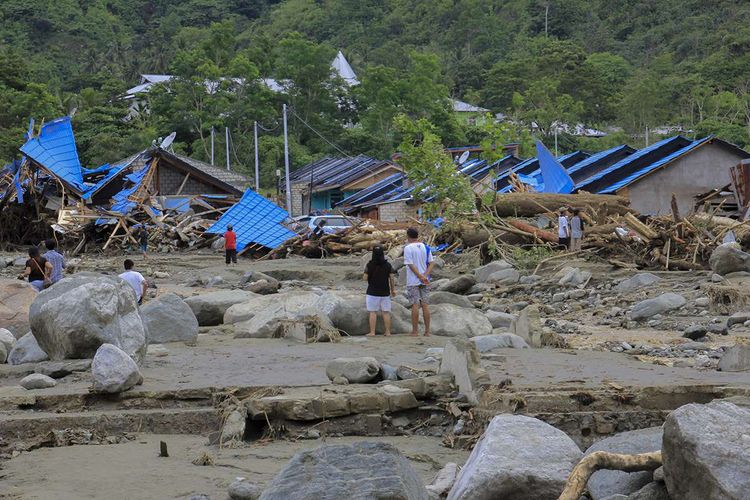 Sejumlah warga melihat rumah yang rusak akibat banjir bandang di Sentani, Kabupaten Jayapura, Papua, Minggu (17/3/2019). Jumlah korban bencana banjir bandang yang terjadi pada Sabtu (16/3/2019) malam kemarin, hingga data yang masuk pada Minggu sore, terus bertambah menjadi 63 orang.
