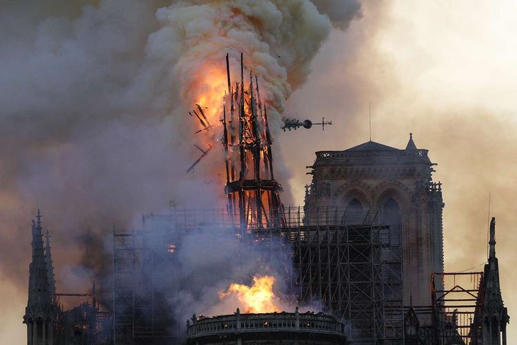 Api membakar bagian atas Gereja Notre Dame di Paris, Perancis, pada Senin (15/4/2019). Belum diketahui penyebab pasti kebakaran itu, api dengan cepat melalap atap dan puncak menara gereja bernuansa Gotik yang dibangun pada abad ke-12 itu.