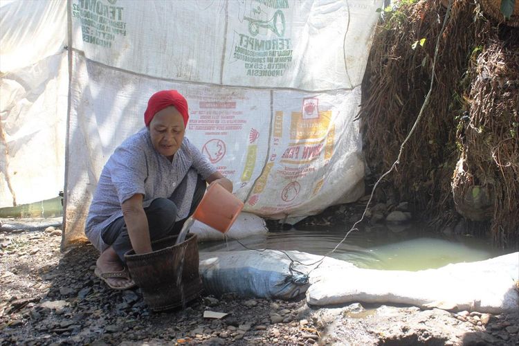 Seorang warga di Desa Cisalak, Kec. Cibeber, Kab. Cianjur, Jawa Barat tengah memanfaatkan air kubangan Kali Cisalak untuk kebutuhan mencuci, Minggu (21/072019) menyusul krisis air di wilayah tersebut sejak dua bulan terakhir. 