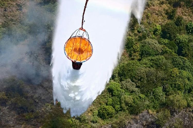 Operasi pemadaman kebakaran hutan melalui helikopter pengebom air di Gunung Arjuno, Jawa Timur, Minggu (4/8/2019)