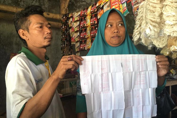 Suliono dan Suparmi, pemilik warung di dekat lokasi proyek pembangunan Rusunawa Kota Mojokerto, menunjukkan catatan tagihan pekerja proyek yang belum dibayar.