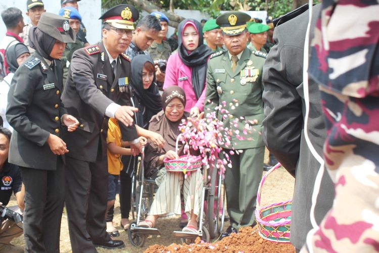 Sadiah (70), ibunda almarhum Ipda Erwin Yudha Wildani (45) turut tabur bunga di atas kuburan anaknya di Taman Maka Pahlawan, Cikaret, Cianjur, Jawa Barat, Senin (26/08/2019).