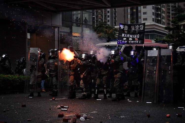 Polisi menembakkan gas air mata ke arah pengunjuk rasa pro-demokrasi, saat terjadi bentrokan di Tseun Wan, Hong Kong, Minggu (25/8/2019). Aksi protes telah bergulir selama 3 bulan terakhir di Hong Kong, dimulai ketika Kepala Eksekutif Hong Kong Carrie Lam memperkenalkan undang-undang yang bisa mengekstradisi kriminal ke China daratan.