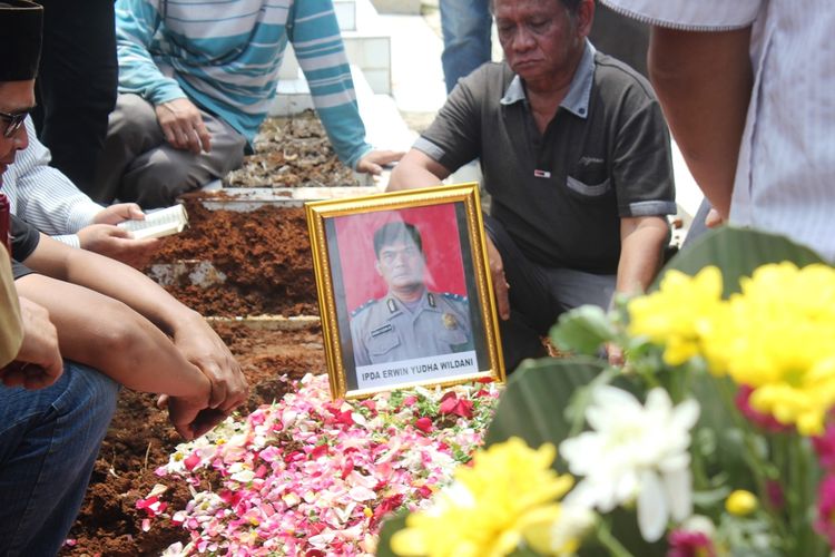 Keluarga dan kerabat berdoa di atas kuburan Ipda Erwin Yudha Wildani (45) di Taman Makam Pahlawan Cikaret, Cianjur, Jawa Barat, Senin (26/08/2019)