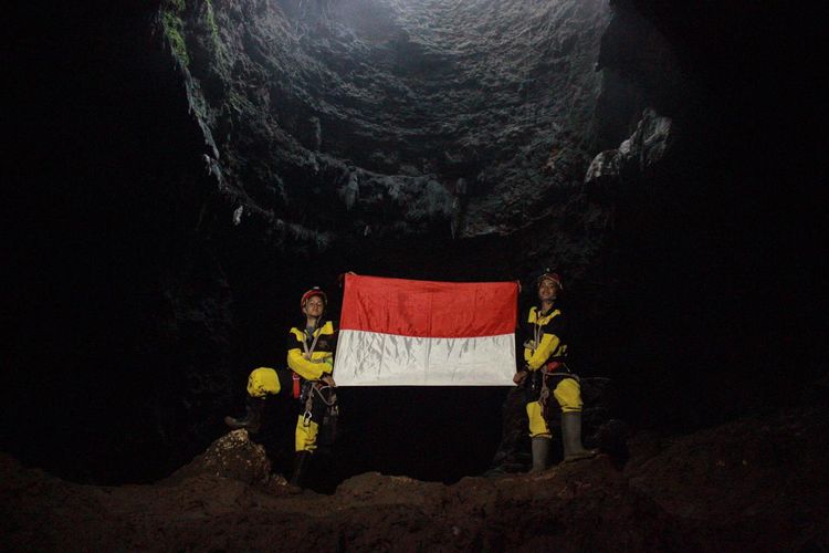 Penelusur goa Mapala UI mengibarkan bendera Merah Putih di dasar Goa Grubug, Gunungkidul, Yogyakarta.