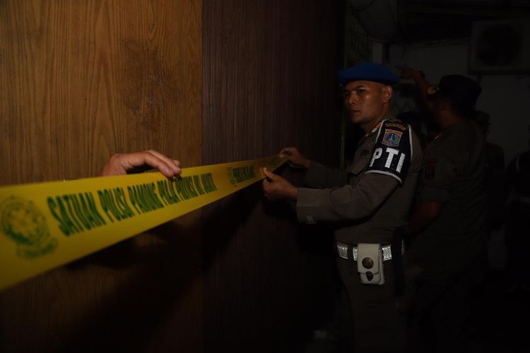 Petugas Satpol PP memasang garis saat menutup sebuah tempat karaoke di Pejagalan, Jakarta Utara, Jumat (10/5/2019).