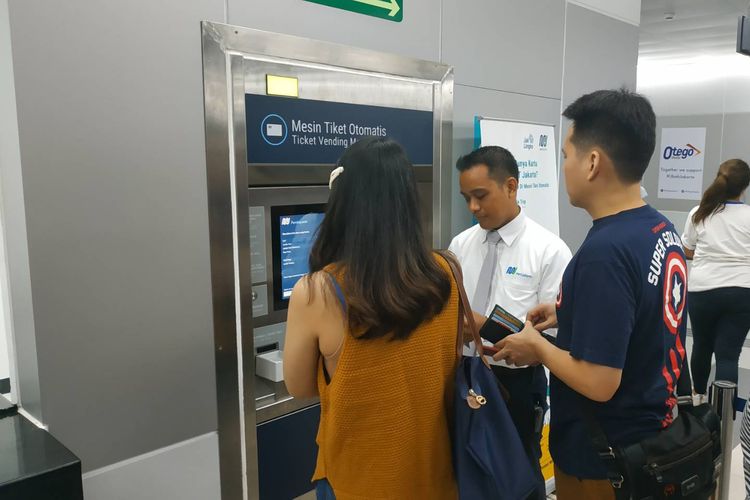 Penumpang MRT membeli tiket melalui mesin tiket otomatis didampingi petugas di Stasiun MRT Bundaran HI, Kamis (11/4/2019).