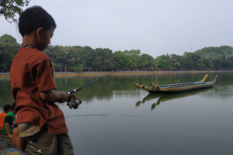 Seorang anak sedang memancing di Setu Babakan, Jakarta Selatan, Jumat (!7/5/2019).
