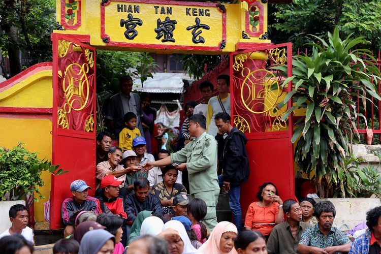 Petugas saat membagikan duit kepada pengemis di Kelenteng Kim Tek Ie atau Vihara Dharma Bakti, Glodok, kawasan Petak Sembilan, Jakarta Barat, Sabtu (28/1/2017). Warga keturunan Tionghoa melakukan sembahyang sebagai ungkapan syukur merayakan Tahun Baru Imlek 2568 dengan Shio pada imlek tahun ini adalah Ayam Api.