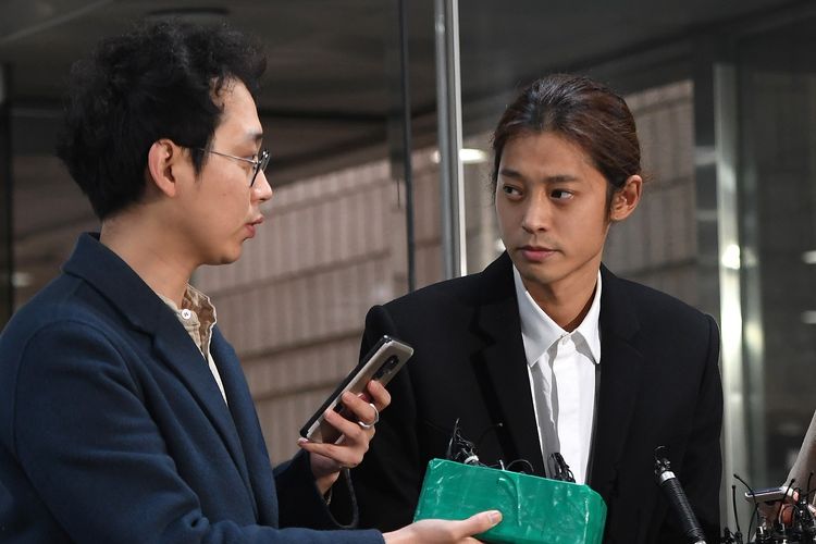 Bintang K-pop Jung Joon Young (kanan) tiba di pengadilan pusat Seoul, Kamis (21/3/2019). Ia menjadi tersangka kasus perekaman dan penyebaran video seks.
