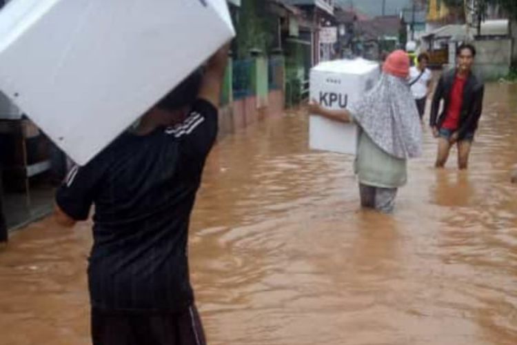 Petugas KPPS di Cimanggung, Sumedang, Jawa Barat terobos banjir untuk pindah lokasi TPS, Selasa (16/4/2019) sore.
