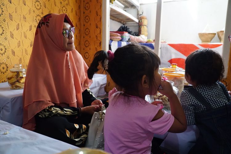 Salah satu anak yang akan menjalani pemotongan rambut gembel, Kayang Ayuningtiyas Nugroho (tengah), didampingi ibunya di rumah Tua Adat Ki Sumanto, di kawasan Dieng, Jawa Tengah, Sabtu (3/8/2019). 