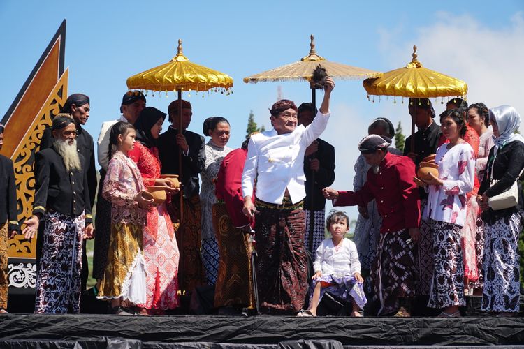 Kayang Ayuningtiyas Nugroho (duduk) saat menjalani ritual potong rambut gembel, Minggu (4/8/2019).