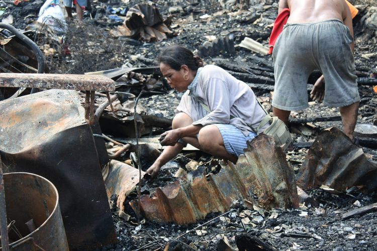 Seorang wanita mencari puing di tengah sisa kebakaran permukiman di RT 10 RW 01, Kelurahan Semenan, Kecamatan Kalideres, Jakarta Barat, Kamis (29/8/2019).