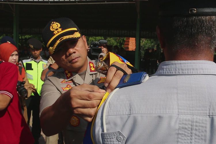 Kapolres Cirebon, AKBP Suhermanto memasangkan pita di pundak salah satu personel dalam apel operasi ketupat 2019 di Gor Ranggajati Cirebon, Selasa (28/5/2019). 
