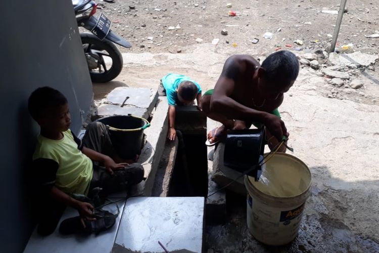 Seorang warga sedang menimba air sumur akibat kesulitan mendapat air bersih akibat sambungan pipa milik PDAM Kota Bogor mengalami kebocoran, Jumat (7/6/2019).