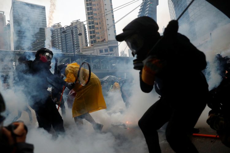 Para peserta demo Hong Kong ketika menghindari gas air mata dari polisi Minggu (25/8/2019).