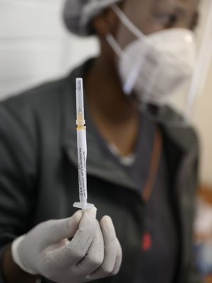 Petugas medis memperlihatkan vaksin uji coba klinis pertama yang dibuat South African Oxford sebelum menyuntikkannya ke relawan di RS Baragwanath di Soweto, Afrika Selatan. Gambar diambil pada 24 Jni 2020. 