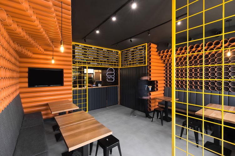 Interior restoran didesain dengan menggunakan pipa PC berwarna oranye