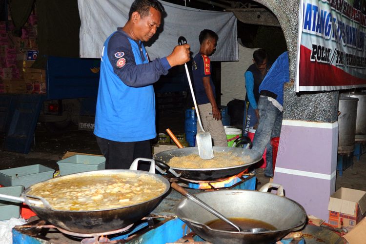 Relawan dari Taruna Siaga Bencana (Tagana), Hidayat, menyiapkan makan sahur bagi warga terdampak banjir di Dusun Beluk Desa Jombok Kecamatan Kesamben Kabupaten Jombang, Senin (6/5/2019) dinihari.                       